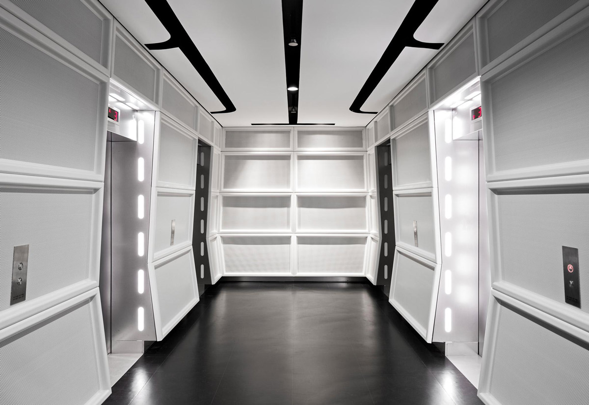 Aedas Interiors’ Lucasfilm Singapore office is shown with a cinematic, Star Wars–inspired lift lobby featuring illuminated vertical light strips, dark polished flooring, and modular wall panels. The image highlights a themed interior environment designed for immersive storytelling, wayfinding through light guidance, and a controlled low‑light workspace supporting frequent collaborative reviews and production workflows.