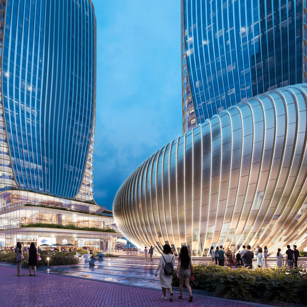 Aedas’ Jing Brand Wuhan development with twin glazed towers above a sculpted retail podium and public plaza. Evening ground‑level view of the Aedas‑designed Jing Brand development in Wuhan, showing two high‑rise glass towers rising from a curvilinear, multi‑storey retail podium. The podium features floor‑to‑ceiling glazing, layered horizontal fins and a central atrium volume opening onto a landscaped pedestrian plaza with integrated lighting and circulation.