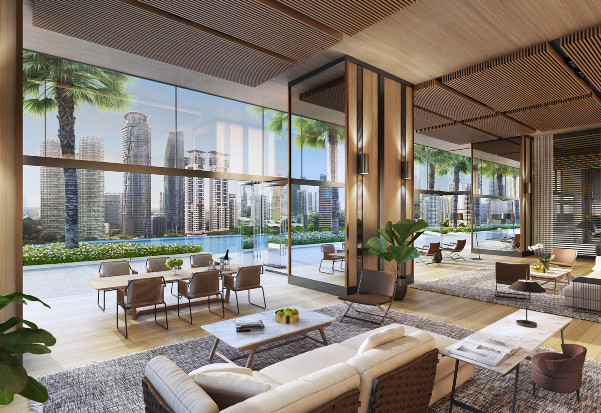 Aedas Interiors’ Jumeirah Residences Kuala Lumpur is shown as an open residential lounge with full‑height glazing overlooking a landscaped terrace and city skyline. The interior features timber slatted ceilings, warm neutral furnishings, integrated greenery, and flexible seating areas, highlighting a refined, resort‑style living environment that blends indoor–outdoor continuity with contemporary residential luxury.