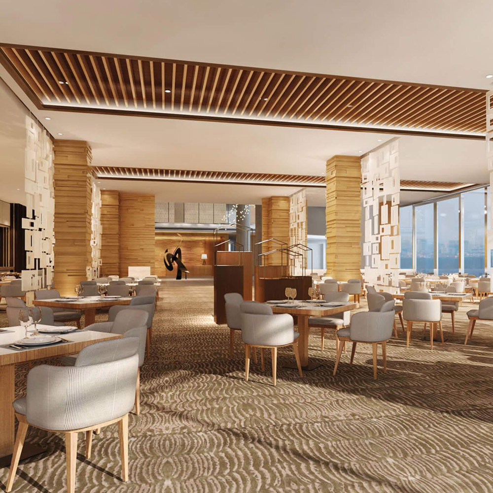 Aedas Interiors’ Holiday Inn Nanjing is shown as a contemporary all‑day dining interior with warm timber columns, layered slatted ceiling panels, light‑toned upholstered chairs, and patterned carpet flooring. The image highlights a rhythmic spatial composition inspired by the Qinghuai riverfront, combining natural textures, soft lighting, and open seating to create a calm, refined hospitality environment overlooking the city.