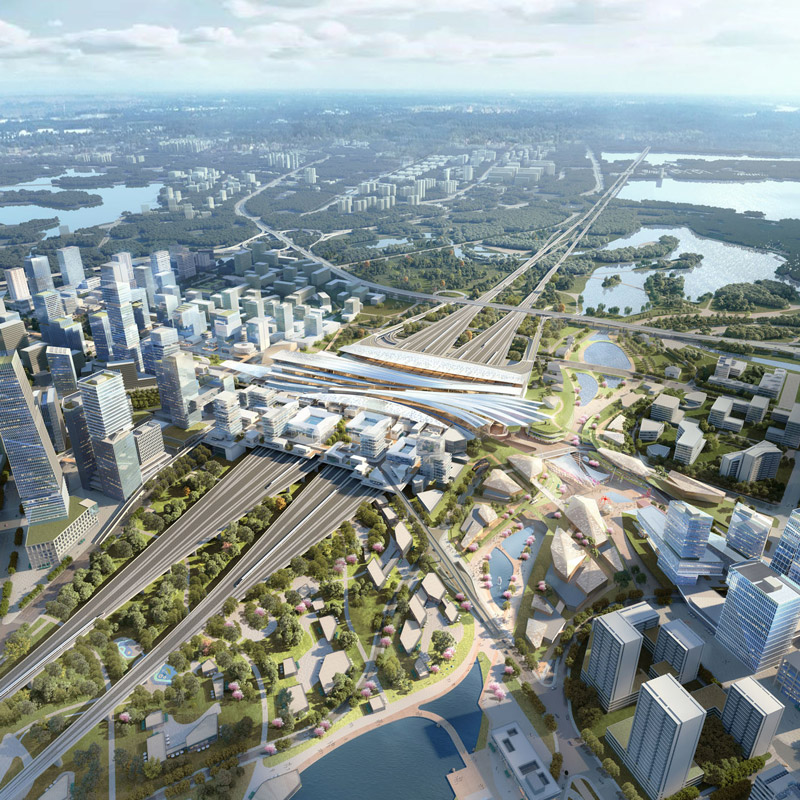 Aedas’ Wuhan Hanyang Station–City Integrated Area is shown as a large‑scale transit‑oriented urban masterplan with a central high‑speed rail hub, layered station roofs, and radiating transport corridors. The aerial view highlights an East–West dual‑core layout integrating rail infrastructure, dense mixed‑use clusters, waterways, and expansive ecological landscapes to form a cohesive, future‑ready transportation and city centre.