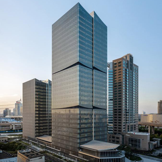 Aedas’ Shanghai International Fortune Centre is shown as a pair of rectilinear glazed office towers rising above a shared podium. The image highlights refined curtain‑wall façades with subtle horizontal articulation, a bridging podium accommodating retail and F&B uses, and landscaped ground‑level spaces that integrate the development into the surrounding Jinqiao business district with a calm, contemporary corporate presence.