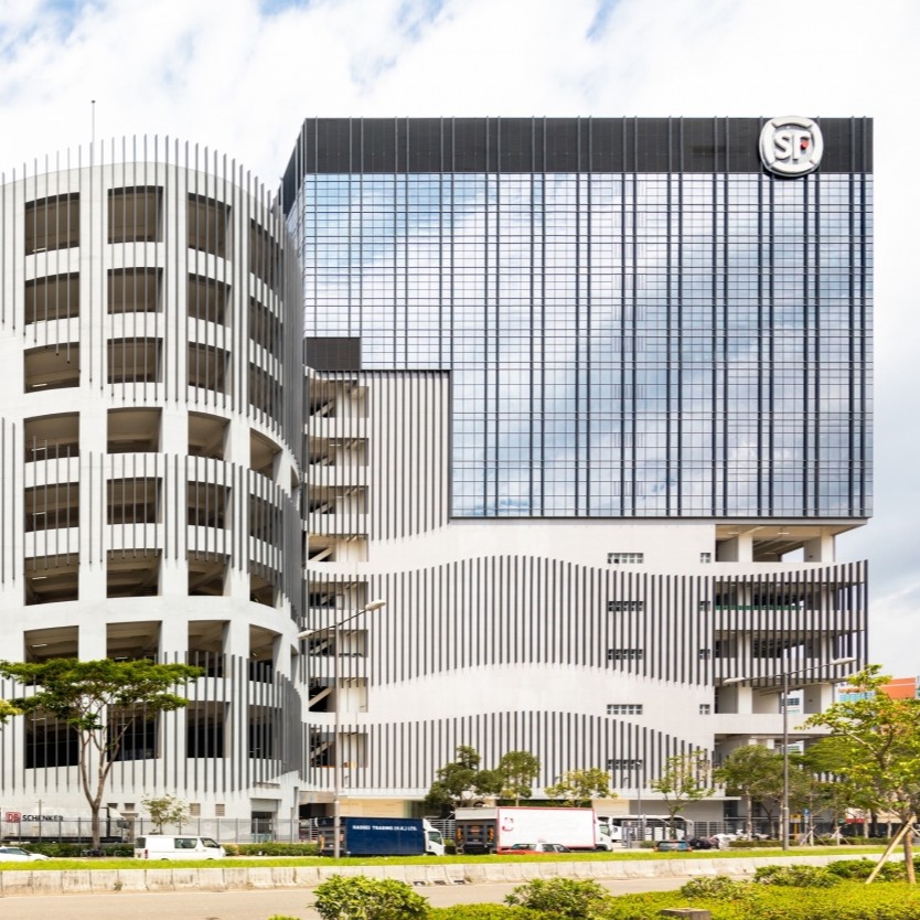 Aedas’s Asia Logistics Hub – SF Centre in Hong Kong is shown as a high‑rise logistics and office building with a rectilinear tower, high‑performance glazed curtain wall, and multi‑storey podium base. The exterior highlights large‑scale industrial architecture integrated into a dense urban environment with clear structural and façade articulation.
