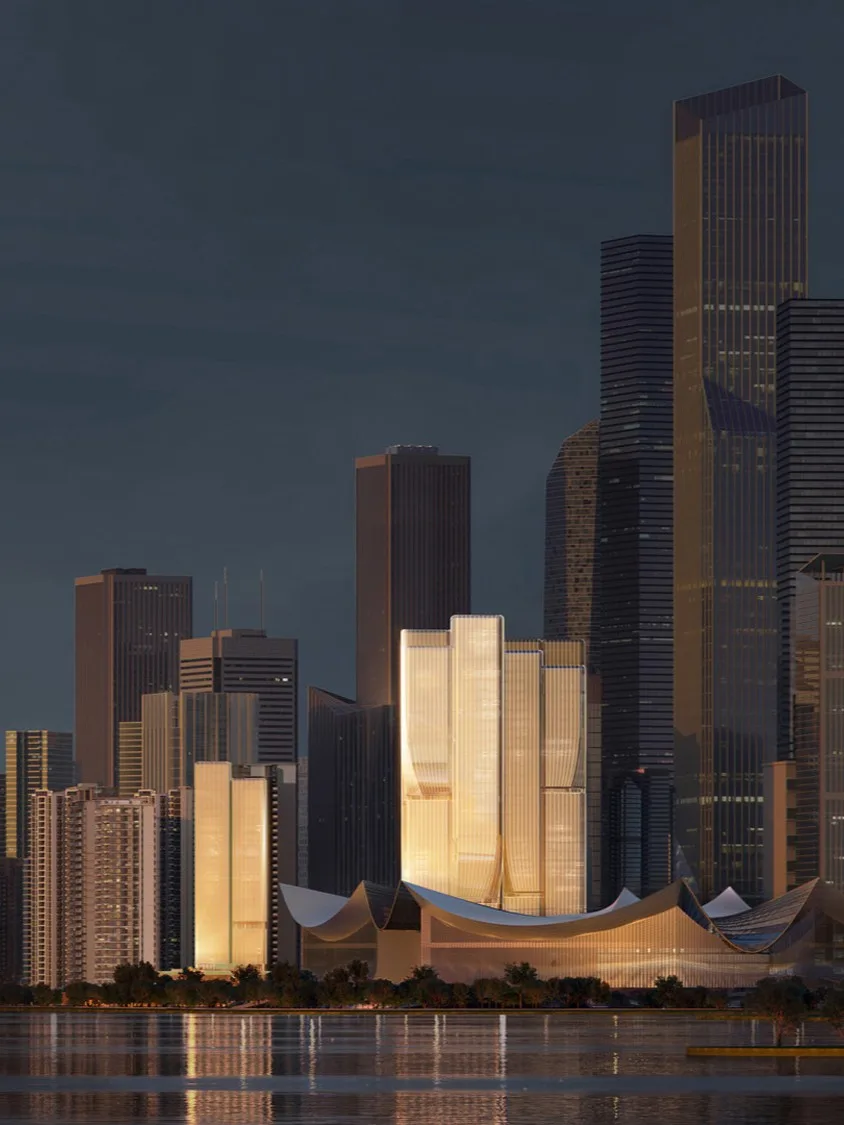 Aedas’ Hengli Island Plot 2021NJY‑12 Mixed‑use Project in Guangzhou is shown as an iconic waterfront commercial landmark with sculptural twin towers clad in champagne‑toned glass rising from a fluid podium. The image highlights organically contoured massing inspired by magnolia blossoms and waves, illuminated façades reflecting sea and sky, and layered podium forms integrating Lingnan‑influenced public spaces, retail, and landscaped terraces, establishing a refined financial‑island skyline presence.