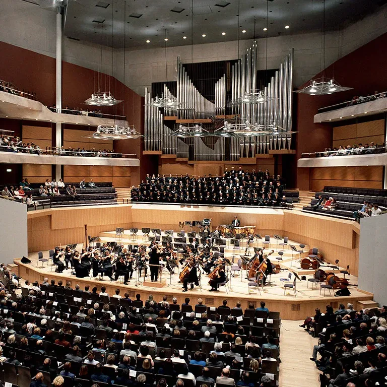 Aedas’s Bridgewater Hall in Manchester is shown as a purpose-built concert hall architecture with a terraced auditorium configuration, central performance platform, suspended acoustic reflectors, and a unified acoustic volume. The image demonstrates performance-led spatial geometry, large-capacity cultural infrastructure, and architectural integration of structure, acoustics, and circulation.
